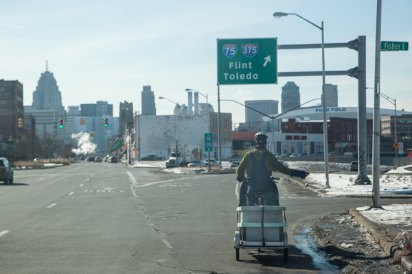Jack VanDyke pedals down Gratiot to make deliveries for Rising Pheasant Farms