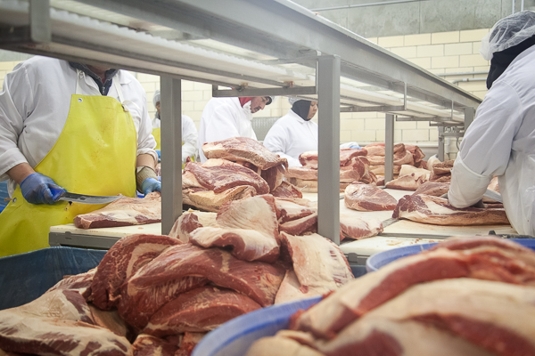 Workers trim brisket at United Meat and Deli