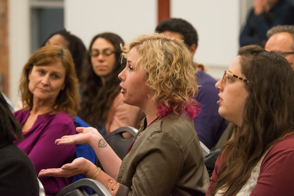 An audience member asks the panelists a question