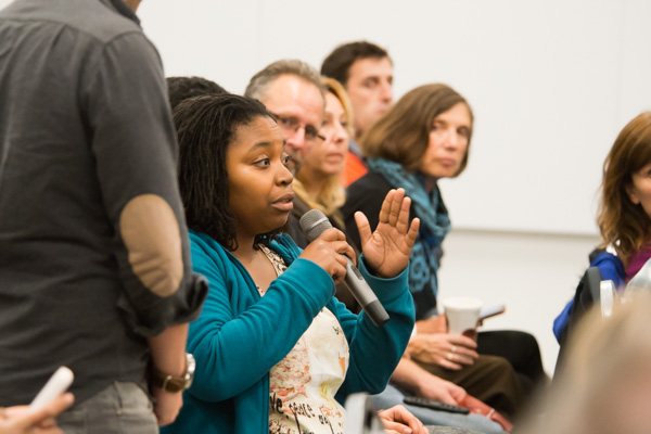 An audience member asks the panelists a question