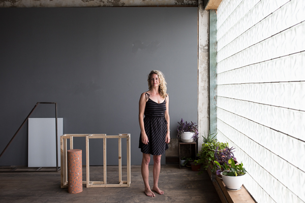 Andrea Eckert next to the work of Holding House resident artist Emily Duke