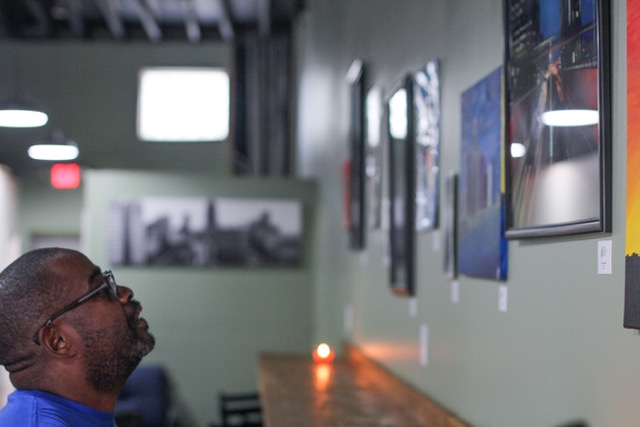 Community member looks at art on the wall of Detroit Sip