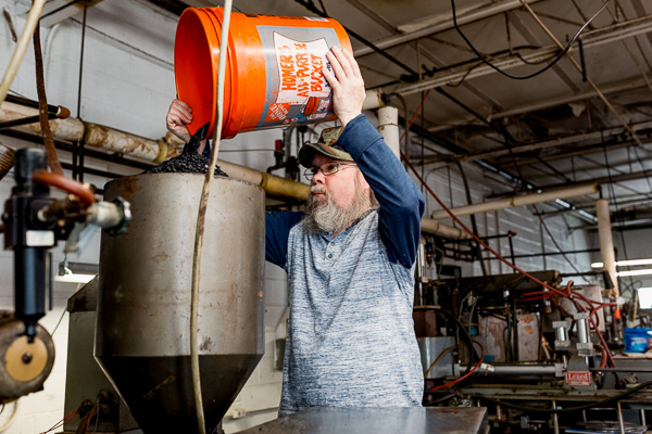 Ken Moravik, Archer Records press operator, pouring virgin vinyl in the press's hopper