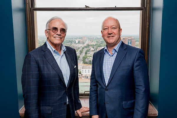 Cummings and Knoer in front of their office window in the Fisher Building looking down East Grand Boulevard