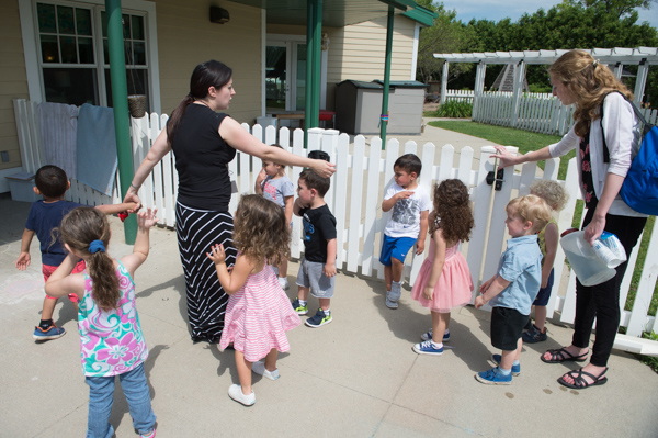 UM Dearborn Early childhood Education Center teacher Charlene Hughes left, and assistant Michelle King, right, gather their class