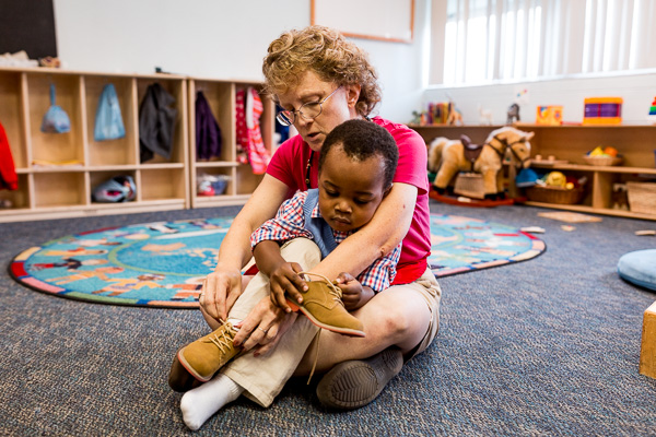 Michelle Smith helps put on a toddler's shoes