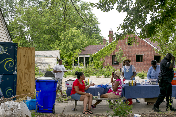 Community residents sit and chat at the cookout