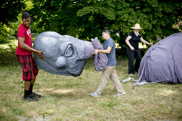 Puppeteers James Abbott and Mike Chin carry and elephant puppet created by Lindsay McCaw
