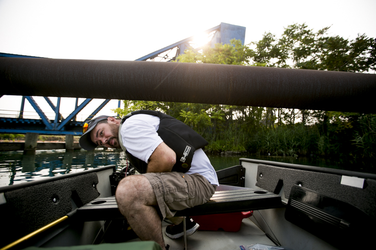 Charley Speiss ducks under a pipe that juts out into the water