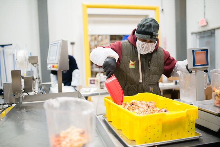 Employees prepare Michigan-grown carrots to be frozen.