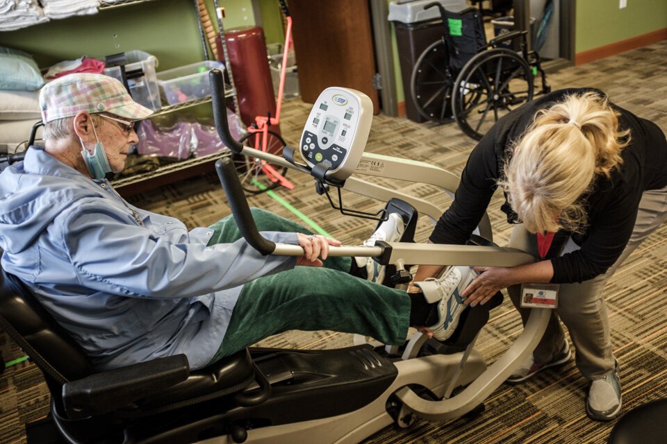 A PACE participant is helped onto an exercise bike at the LifeCircles Center in Muskegon. PACE participants are encouraged to stay active and move their bodies with low-impact exercise, keeping them mobile and independent for longer.