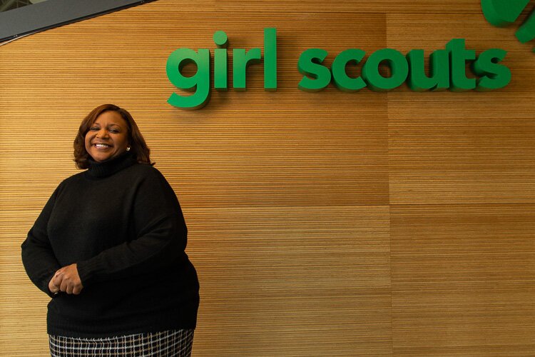 Monica Woodson, CEO for Girl Scouts of Souheastern Michigan, stands near a sign at the entrance to the Council's headquarters in Detroit.