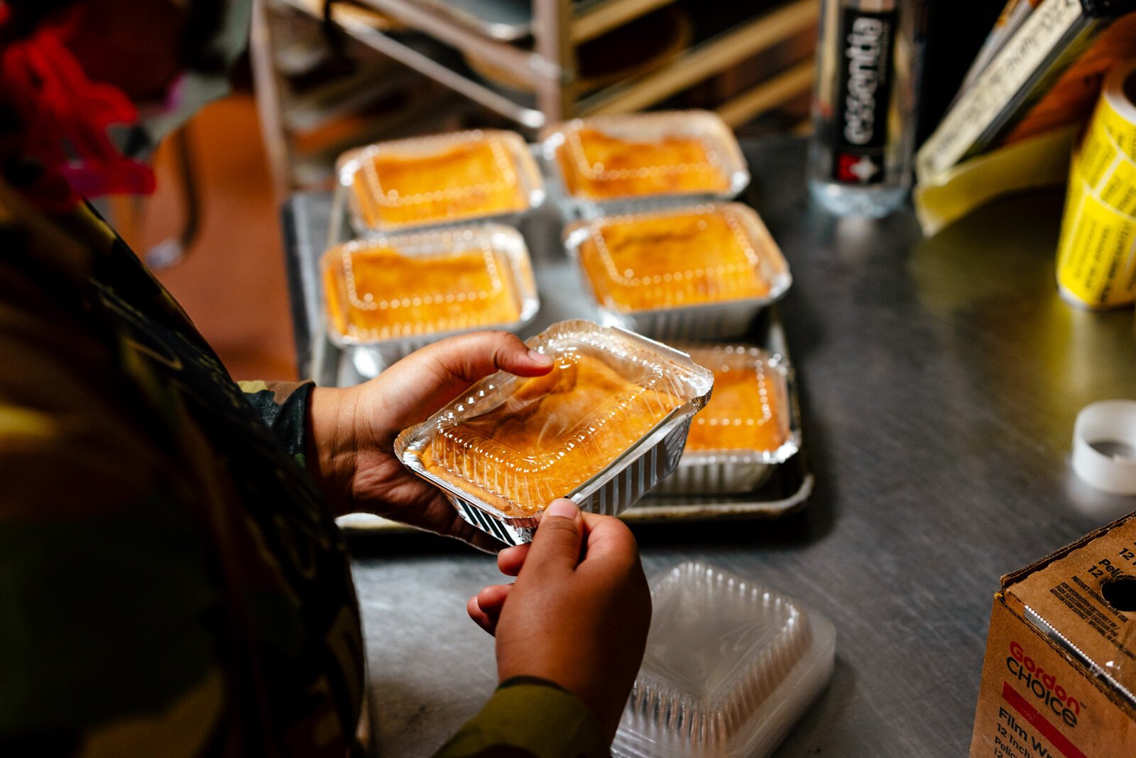 Staff packaging and labeling sweet potato cheesecakes.