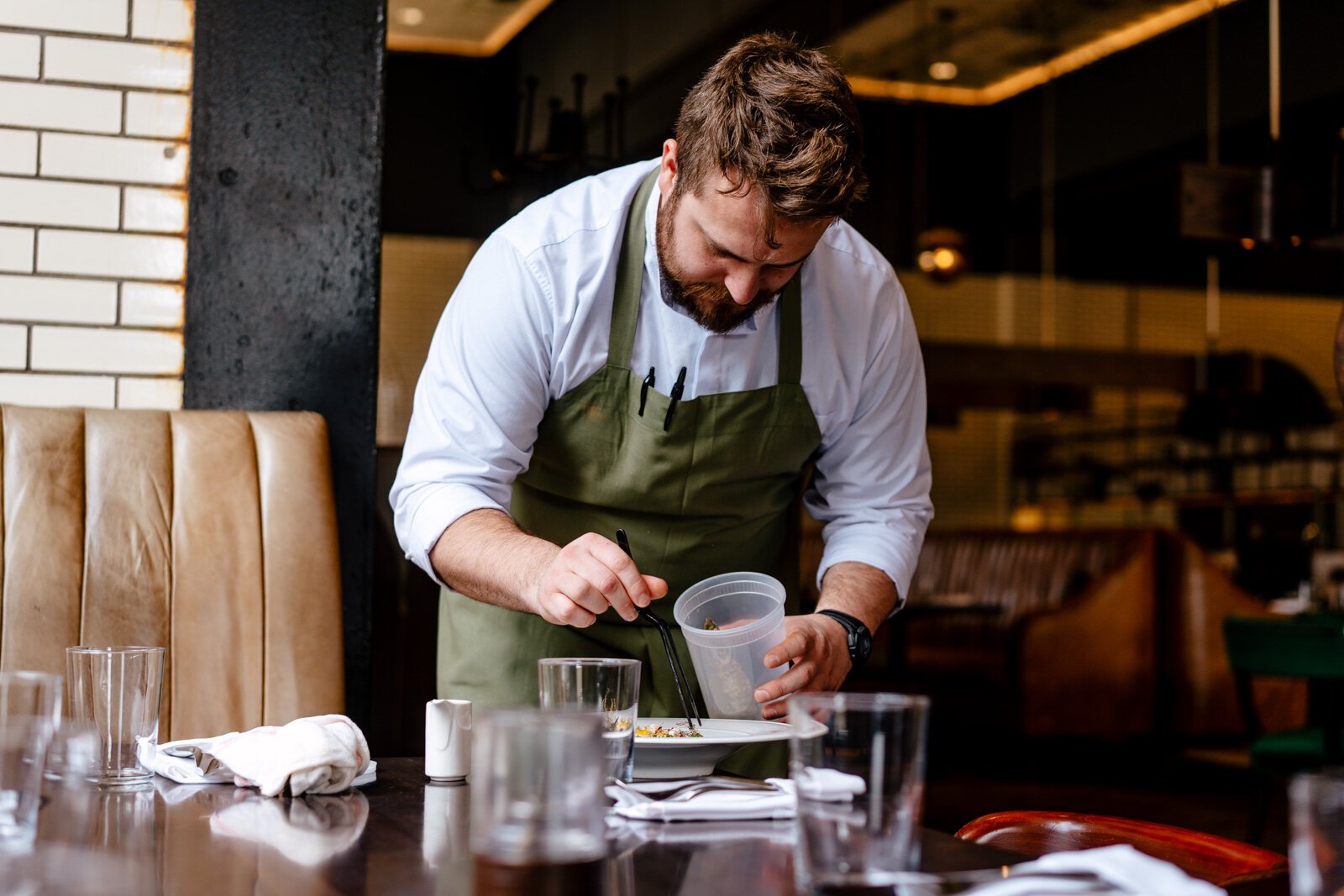 Ken Miller places cooked wild garlic roots to a roast sablefish dish.