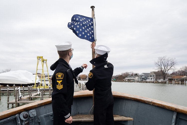 Cadets hoist a flag on the Pride of Michigan.