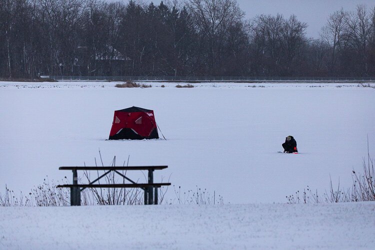 Ice fishermanfishes near a shanty at Stony Creek.