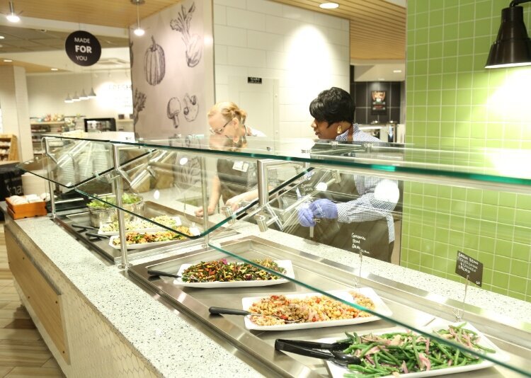 Personal de Corewell Health sirviendo comida en The Green Beet.