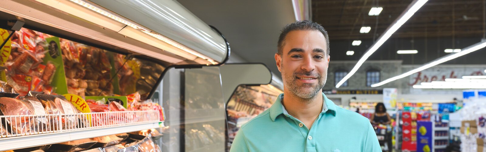 Vincent Nona stands inside the Parkway Foods grocery story. 